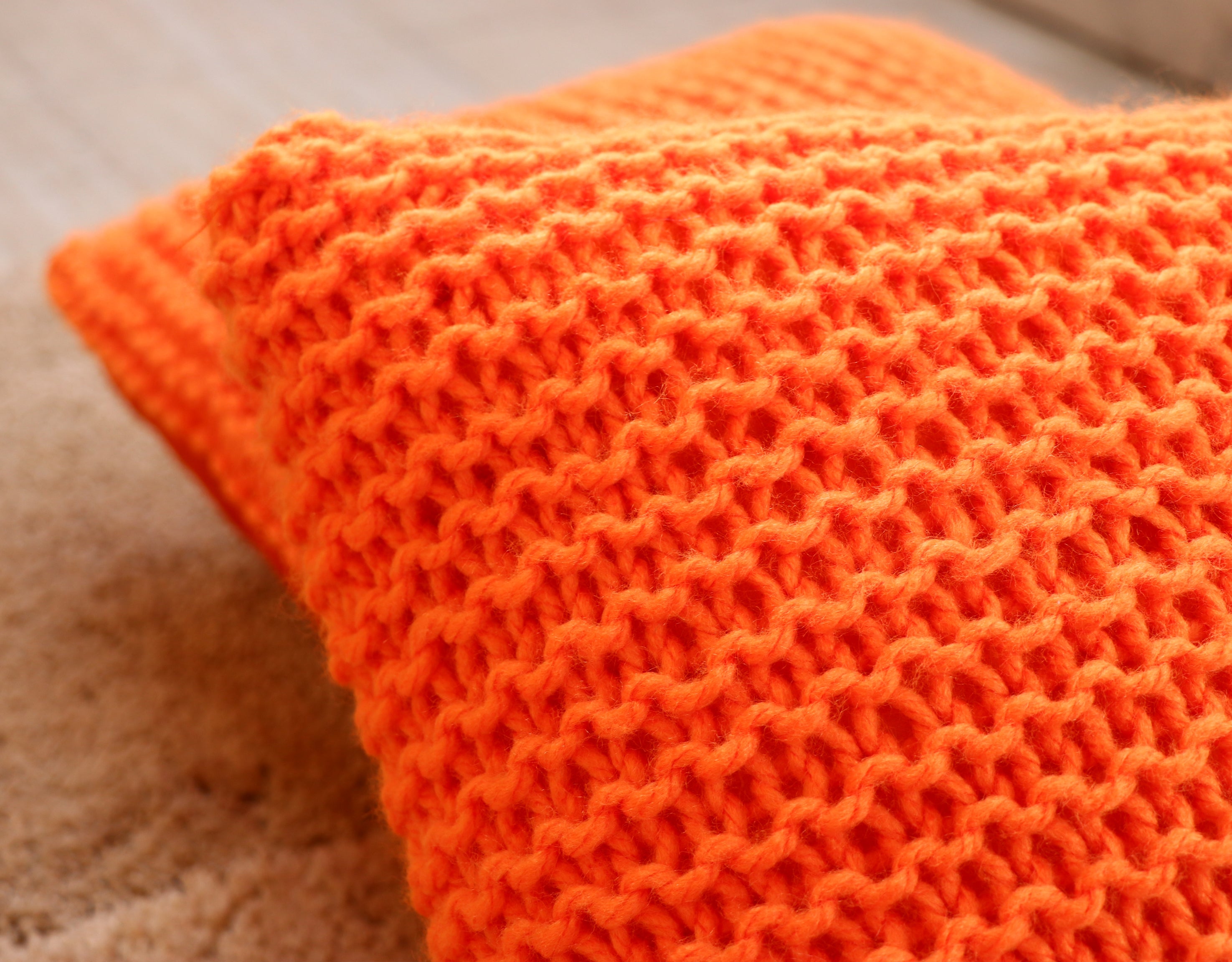 Orange hand knitted cushions by artisans of India for winter season